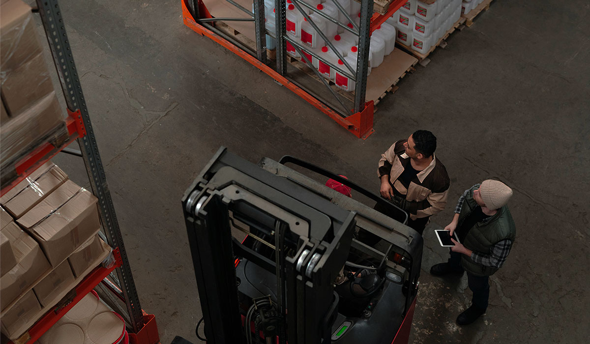 cariste conduisant un chariot élévateur en entrepôt