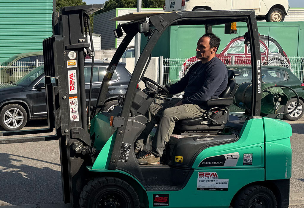 Un opérateur décharge du matériel depuis un camion à l’aide d’un chariot élévateur (fenwick)